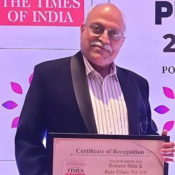 Dr. Shrikant Kogekar holding a certificate of recognition.